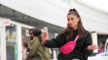 Woman using smartphone indoor. Texting and communicating in mall photo