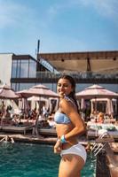 Young woman on the background of the pool in a white swimsuit. photo