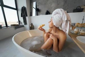 Luxury fashion woman in the morning take breakfast lying in bath photo