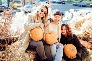 Girls holds pumpkins in hands on the background of the street. photo