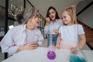 Family doing chemical experiment, mixing flasks indoors photo