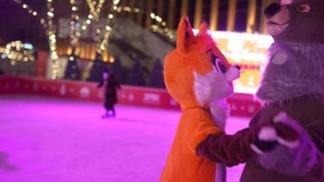 People enjoy ice skating in the street around Christmas tree in rink. photo
