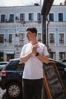 Man in gray t-shirt and jeans over city street background photo