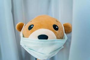 mascarilla protectora médica desechable en oso de peluche marrón foto
