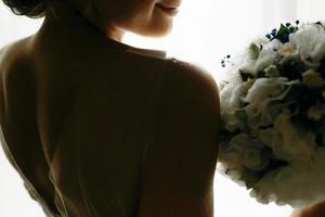beautiful bride in a wedding dress, by window. photo