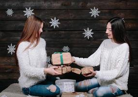 dos hermosas chicas juntas desempacan regalos foto