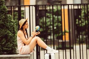 Beautiful young woman holds a small globe in her hands. photo