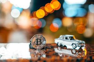 Silver bitcoin and Moskvich 401 on the table, glowing background photo