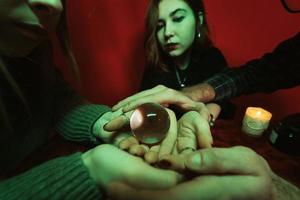 Group of people and woman fortune teller with crystal ball photo