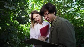 Young agricultural engineers working in greenhouse photo