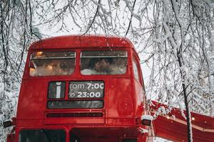 amorosa pareja joven besándose en el autobús rojo, disfrútense unos a otros foto