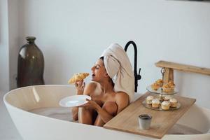 Luxury fashion woman in the morning take breakfast lying in bath photo
