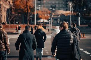 Lots of people crossing the street at the traffic lights. photo