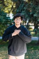 Portrait of happy young male student with glasses in casual outfit photo