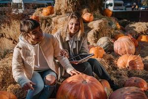 Girls have fun among pumpkins and haystacks on a city street photo