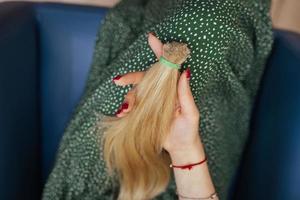 mujer joven sosteniendo su cabello castaño largo recién cortado en colas de caballo foto