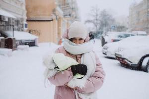 girl with a dog in her arms, snow is falling photo