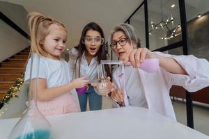 familia haciendo experimentos químicos, mezclando matraces en el interior foto