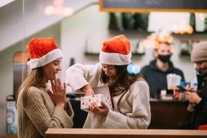 The girl gives a gift to her female friend in caffe photo
