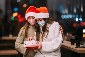 The girl gives a gift to her female friend in caffe photo