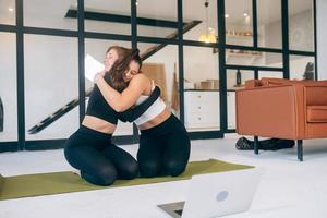 Two girlfriends hug each other after yoga photo