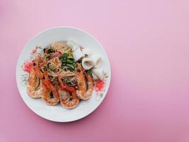 Rice Vermicelli Noodles seafood Spicy Salad on pink background with copy space photo