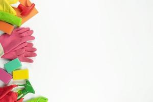 Pink rubbers, colorful sponges and cleaning supplies lie on a white table in the kitchen photo