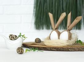 Funny Easter eggs lie in a straw nest as a decoration for happy hollidays photo