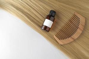 un aceite o suero para el cuidado del cabello en cápsulas doradas sobre un cabello rubio, maqueta de marketing de productos. un concepto de cuidado del cabello en un salón o en casa foto