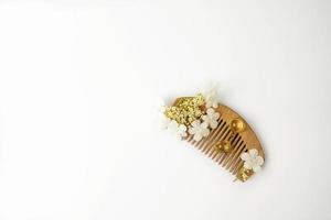 cápsulas doradas de vitaminas de aceite natural para el cabello sobre un peine de madera foto