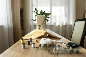 A white sewing machine stands on the table photo