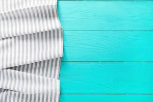 Gray striped tablecloth on blue wooden kitchen. Top view and copy space. Mock up photo