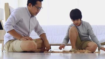 Asian father and son playing wooden puzzles happily love relationship between father and son