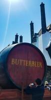 Osaka, Japan on April 10, 2022. A man is standing in front of a barrel of butterbeer. This drink is a signature drink from Hogwarts. photo