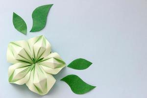 banner con flores de origami verde y hojas de papel con lugar para su diseño. fondo de papel foto