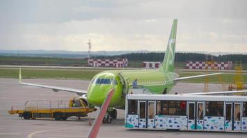 KAZAN, RUSSIAN FEDERATION SEPTEMBER 14, 2020 - passengers disembarking from S7 Airlines Embraer E170 VQ BYV after its arrival to Kazan International airport, view from Control Tower video
