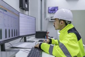 Electrical engineer man checking voltage at the Power Distribution Cabinet in the control room,preventive maintenance Yearly,Thailand Electrician working at company photo