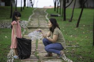 Asian mother and daughter help garbage collection charity environment. photo