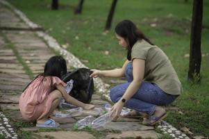 Asian mother and daughter help garbage collection charity environment. photo