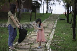 Asian mother and daughter help garbage collection charity environment. photo