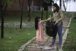 Asian mother and daughter help garbage collection charity environment. photo