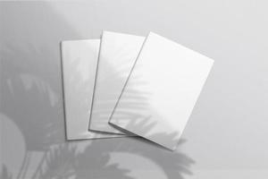 Realistic top view cover and opened portrait A4 or A5 magazine or brochure booklet for stationery and branding. Mockup template isolated light grey background and leaf shadow overlay. 3D rendering. photo