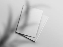 Realistic top view cover and opened portrait A4 or A5 magazine or brochure booklet for stationery and branding. Mockup template isolated light grey background and leaf shadow overlay. 3D rendering. photo