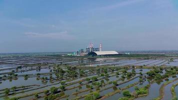 Aerial view of a coal-fired power plant company with a view of the surrounding fish pond cultivation. Drone Videos 4K