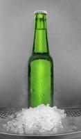 botella de cerveza verde con cubitos de hielo. en tiendas de conveniencia foto