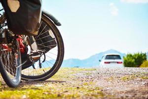 Fully loaded bicycle stand side of road by car pass in nature. Safety on road and bicycle touring concept outdoors photo