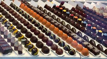 dulces de chocolate belga oscuro en líneas rectas en la ventana de la tienda cerrar foto