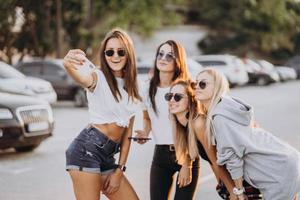 cuatro mujeres jóvenes tomándose un selfie y divirtiéndose foto