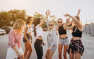 Six young women dance in a car park photo