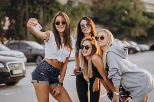 cuatro mujeres jóvenes tomándose un selfie y divirtiéndose foto